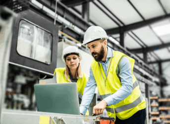 Two people working together in manufacturing plant on the computer