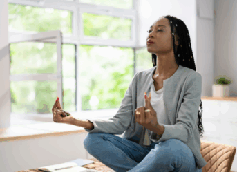 wellness-strategies-manufacturing-environments. Diverse woman meditating at work.